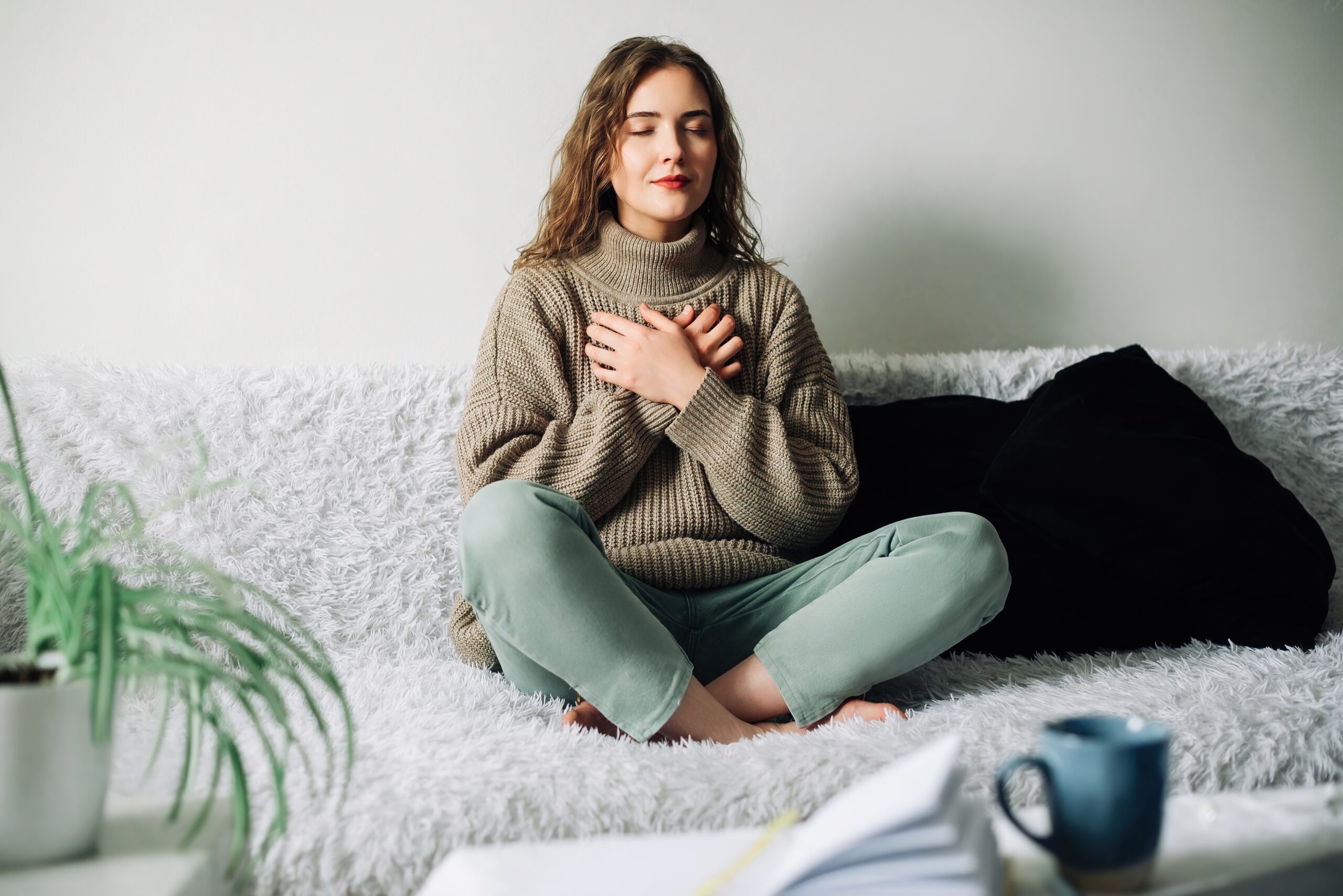 A woman sits calmly with her hands on her chest, eyes closed, practicing a simple technique to reduce stress quickly.